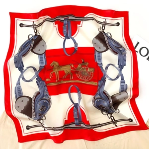 Detailed flat lay of a silk square scarf with vintage carriage and equestrian harness prints