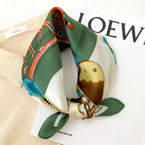 Detail shot of silk square scarf featuring vintage carriage and bird prints in forest green