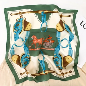 Close-up of elegant forest green silk scarf featuring classic equestrian motif and horse carriage