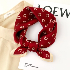 Burgundy silk scarf with white D-pattern and beige border on minimalist background