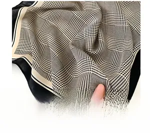 Détail d'un foulard en soie montrant des bords roulés et un motif pied-de-poule