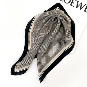 Détail de la texture en soie et du motif pied-de-poule classique sur le foulard carré