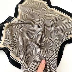Détail du foulard en soie avec motif pied-de-poule montrant la texture lisse et chic