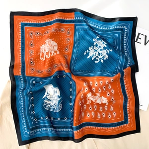 Détail d'un carré de soie avec motif paisley orange et bleu et des éléments nautiques