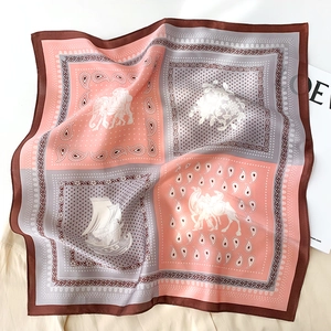 Détail du foulard en soie avec motifs vintage d'éléphants et voiliers sur tissu satiné