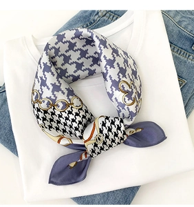 Detail of silk square scarf featuring houndstooth and chain patterns on a casual outfit