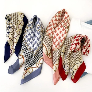 Detail of silk scarves with houndstooth patterns and cute panda icons on satin fabric