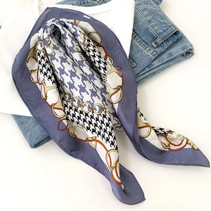 Detailed view of mulberry silk scarf featuring houndstooth and gold chain print patterns