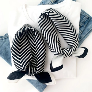 Detail of premium mulberry silk scarf featuring classic black and white V-pattern stripes