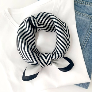 Detailed close-up of a 100% mulberry silk scarf with black and white stripes on a t-shirt