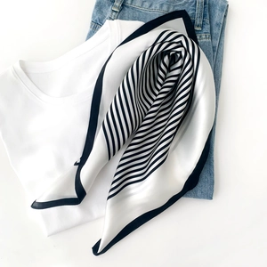 Detailed view of striped silk scarf texture and black border on white background