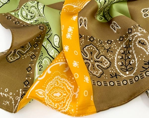 Close-up of paisley silk scarf showing fine texture and olive green color blocks