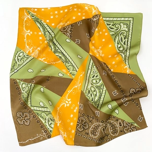 Detailed flat lay of silk-like square scarf featuring paisley and polka dot patchwork