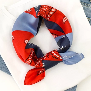 Detailed shot of a colorful paisley silk scarf styled as a stylish neck accessory