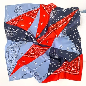 Detail of silk square scarf featuring paisley pattern and red-blue color blocking design
