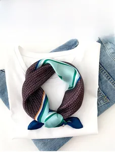 Detail of silk square scarf featuring geometric patterns tied on a white t-shirt