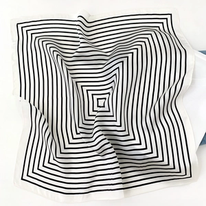 Detail of silk scarf with minimalist black square geometric lines on white fabric