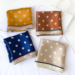 Close-up of four colored silk scarves with white polka dots and delicate edge stitching