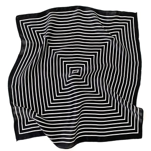 Macro detail of high-quality silk scarf featuring black and white geometric square patterns