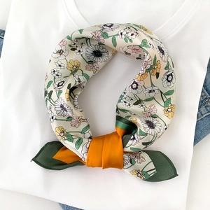 Detail of floral silk scarf featuring daisy patterns and contrast color satin ends