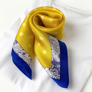 Detailed shot of yellow silk scarf with polka dots and purple paisley patterns