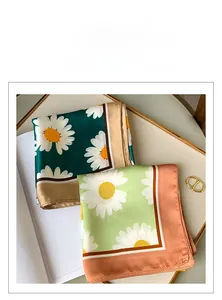 Detail of silk-feel square scarves featuring daisy floral patterns in trendy color combinations