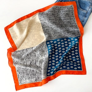 Orange paisley silk square scarf with colorful patchwork pattern and navy blue jeans accent