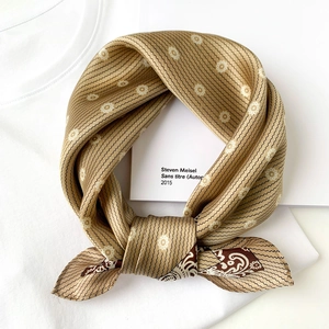 Detail of silk square scarf showing beige floral pattern and smooth shiny texture