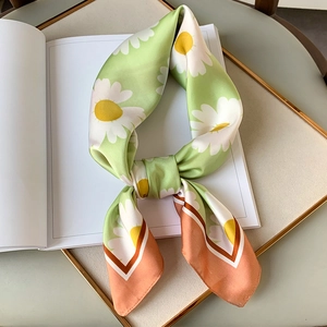 Daisy print satin twilly scarf in green and coral pink on a minimalist book