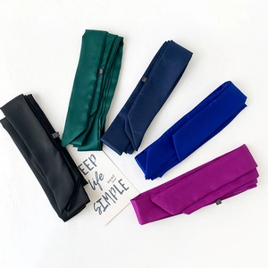 Detail of satin skinny scarves in five vibrant colors with elegant fabric labels