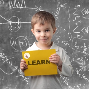 Close-up of a child holding a yellow LEARN card with a dinosaur reward sticker