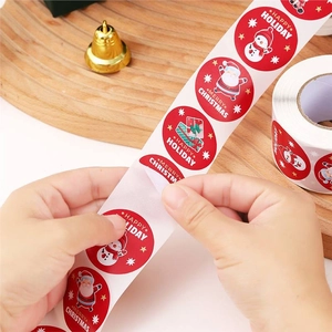 Roll of Merry Christmas cartoon snowman stickers on wood background for gift sealing