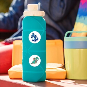 Faltbare grüne Silikon-Kinderwasserflasche mit niedlichen Dinosaurier-Aufklebern im Freien