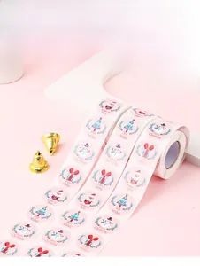 Detail of Christmas snowman sticker rolls on pink background with golden bell decor