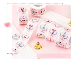 Macro shot of roll-packed cartoon snowman Merry Christmas gift sealing labels and stickers