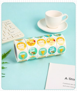 Detail of round reward stickers with motivational text on a mint green desk setup
