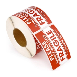 Roll of red and white fragile warning stickers for parcels with handle with care text