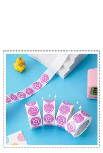 Detail of round purple 'MADE WITH LOVE' adhesive gift stickers on a roll with heart icons