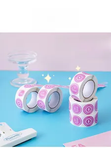 Detail of round 'MADE WITH love' stickers in pink and purple rolls for gift decor