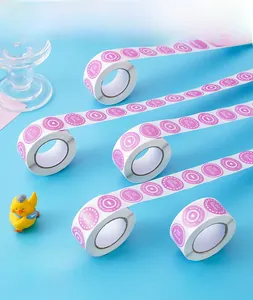 Detail of pink round Thank You stickers roll with heart patterns on bright blue background