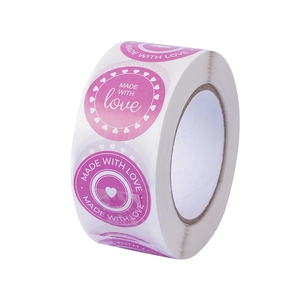 Pink heart shaped stickers roll with Made With Love text for Valentine gift packaging