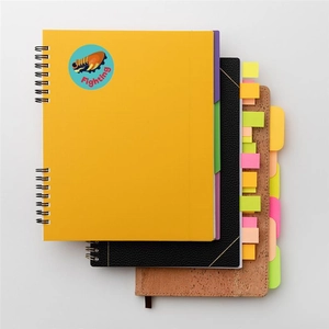 Detail of cork and textured notebooks featuring multi-color index tabs and soccer stickers