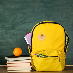 Detail of yellow canvas school backpack featuring a soccer trophy reward patch