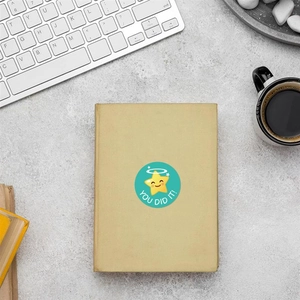 Detail showing a turquoise 'YOU DID IT!' star sticker on a brown notebook cover