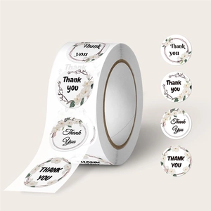 Primo piano di adesivi rotondi Thank You con eleganti disegni floreali bianchi in rotolo