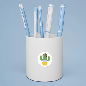 Detail of cartoon cactus sticker on a white pen holder with blue grip gel pens
