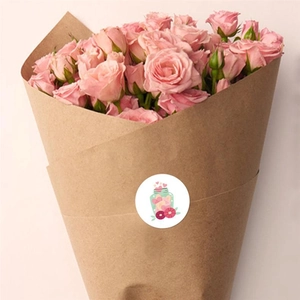 Close-up of heart bottle sticker on brown paper gift wrap with pink roses