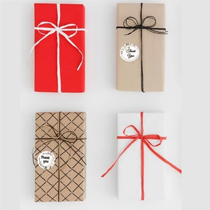 Dettaglio di quattro stili di confezioni regalo con adesivi Thank You e nastri