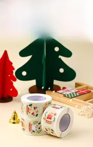 Detail of round Christmas stickers with snowman and holly designs on a cream background
