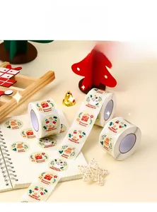 Detail of Christmas gift labels roll featuring snowman and Santa Claus cartoon patterns